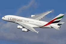 a large emirates airplane is flying through the sky