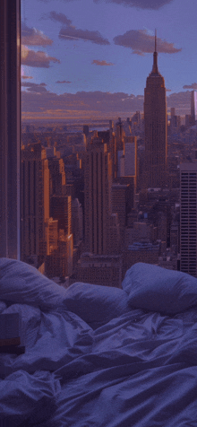 a bed with a view of a city skyline with the empire state building in the distance