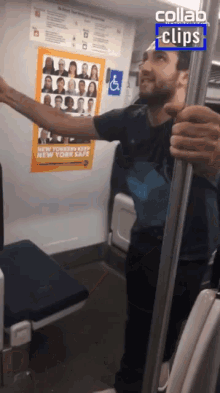 a man in a black shirt is holding a railing in front of a poster that says " make new york safe "