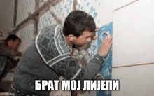 a man is painting a wall with duct tape .