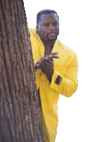 a man in a yellow coat is peeking out from behind a tree trunk .