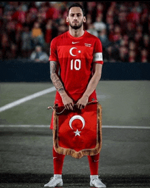 a soccer player with the number 10 on his shirt holds a flag