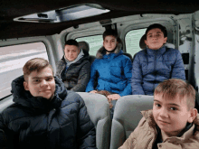 a group of young boys are sitting in a van