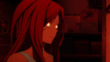 a woman with red hair is standing in a dark room with red eyes .