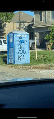 a blue portable toilet with graffiti on it that says " d3p "