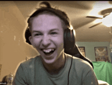 a young man wearing headphones is laughing in a video call