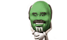 a green m & m with a mustache is being held by a person