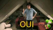 a man is standing in an attic with the word oui written on the wall