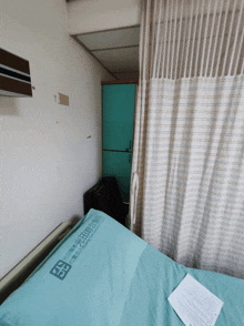 a hospital bed with a blue blanket that says ' taiwan medical institute ' on it