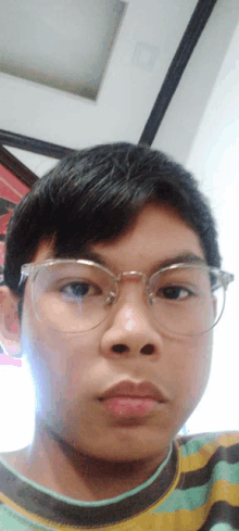 a young boy wearing glasses looks at the camera