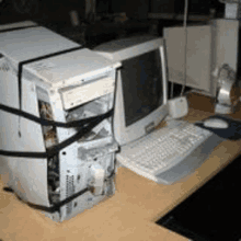 a computer sitting on top of a wooden desk with a monitor and keyboard