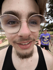 a young man wearing glasses and a purple shirt that says turtle