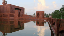 a large brick building is reflected in the water .