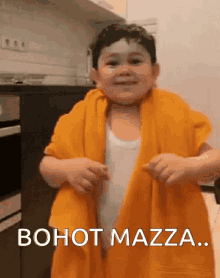 a little boy is wrapped in a yellow towel with the words bohot mazza on the bottom