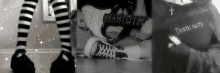 a black and white photo of a person 's legs , a guitar , and a death note sweatshirt .