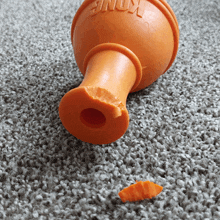 a kong toy with a hole in it is laying on a carpet