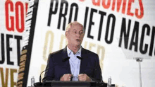 a man in a suit is giving a speech at a podium .