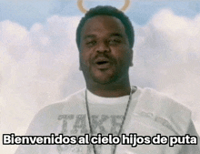 a man in a white shirt is standing in front of a cloudy sky and says bienvenidos al cielo hijos de puta