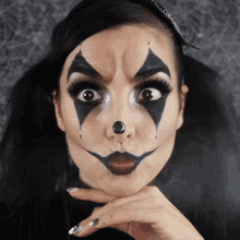 a woman with her face painted like a clown with a black nose