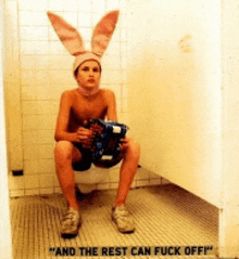 a young boy wearing bunny ears is sitting on a toilet