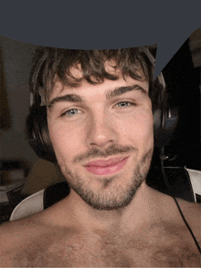 a man with a beard wearing headphones is smiling for the camera