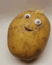 a potato with googly eyes and a smiling face on it .