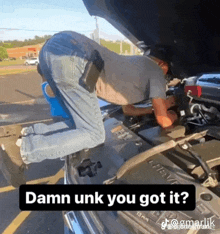 a man is kneeling down under the hood of a car with the caption damn unk you got it