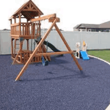 a wooden playground set with a slide , swings and a castle .