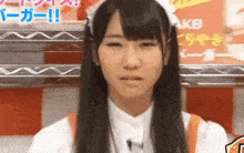 a woman in a maid costume stands in front of an akb sign