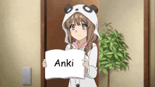 a girl in a panda hood is holding a sign that says anki .