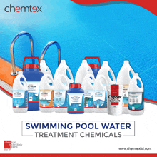 bottles of swimming pool water treatment chemicals lined up in front of a swimming pool