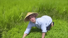 a man wearing a conical hat is kneeling in a field of grass with the word japan written on the bottom