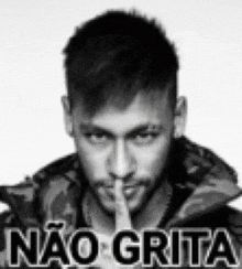 a black and white photo of a man holding his finger to his mouth and saying não grita .