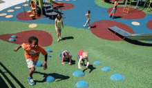 a group of children are playing in a playground with a slide .