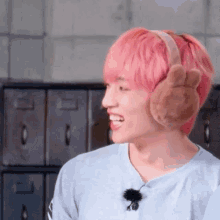 a young man with pink hair is wearing a pair of bunny ear warmers