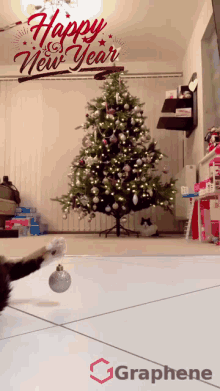 a cat playing with a christmas ornament in front of a christmas tree with the words happy new year above it