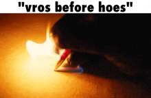 a picture of a person writing with a lighter and the words " vros before hoes " on the bottom