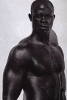 a black and white photo of a shirtless man with muscles .