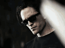 a man wearing sunglasses and a black shirt with the word harley davidson on it