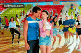 a man and a woman are dancing together in a stadium .