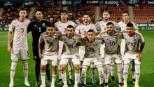 a group of soccer players are posing for a picture on the field