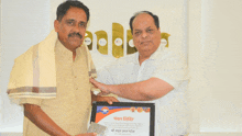 a man holding a framed certificate that says ' shree ashwa ' on it