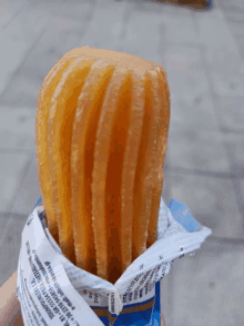 a person is holding a churro in a bag that says ' gourmet ' on the side