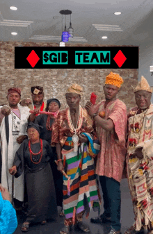 a group of people are posing for a picture under a sign that says $ gib team