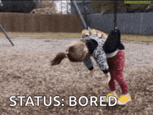 a little girl is upside down on a swing with the words " status : bored " next to her