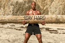 a man is carrying a log that says stay hard on it