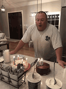 a man wearing a shirt with a shamrock on it stands in front of a cake that has the number 45 on it