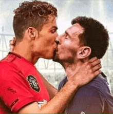 cristiano ronaldo and messi are kissing each other .