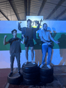 a group of people standing on tires in front of a sign that says post