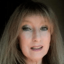 a close up of a woman 's face with long hair and a fringe .